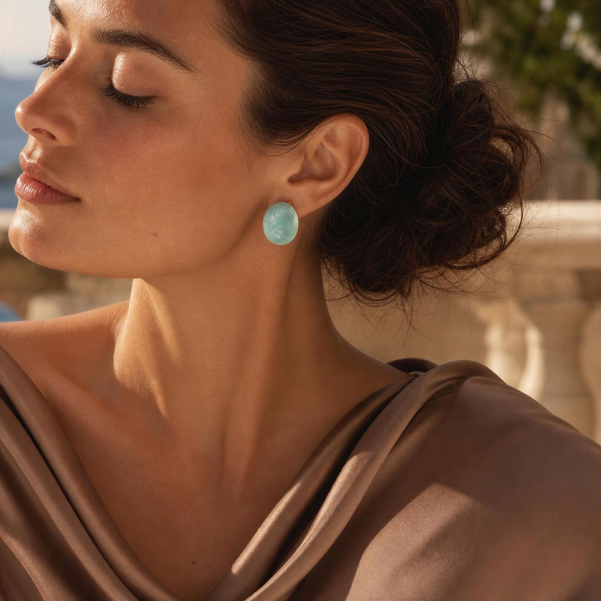 Woman wearing the Rosina Studs -Aqua Glow with a blurred outdoor background