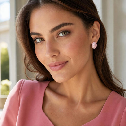 Woman wearing pink earrings with a blurred indoor background
