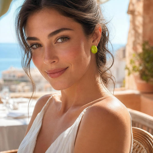 Woman wearing the Rosina Studs - Verde Luxe  sitting outdoors with a scenic view 