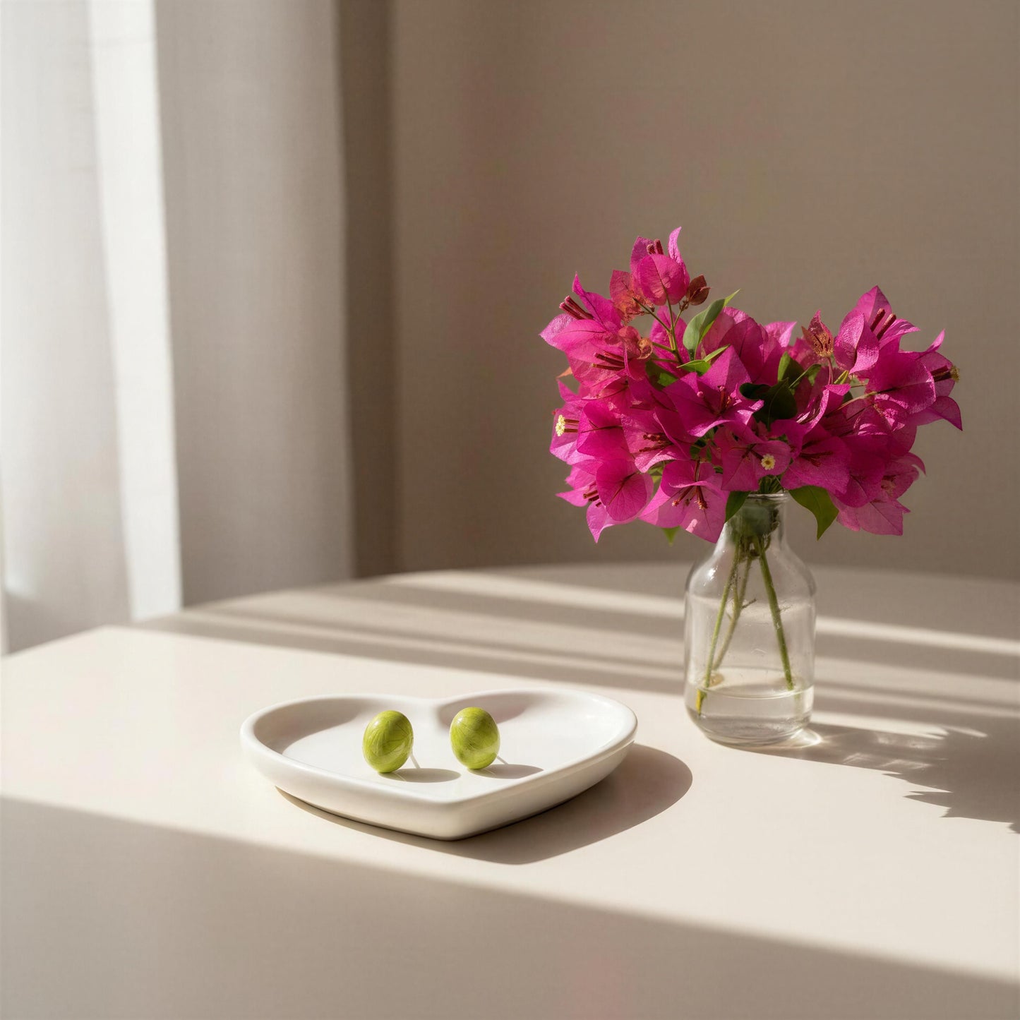 Vase with pink flowers on a table next to a white plate with the Rosina Studs - Verde Luxe