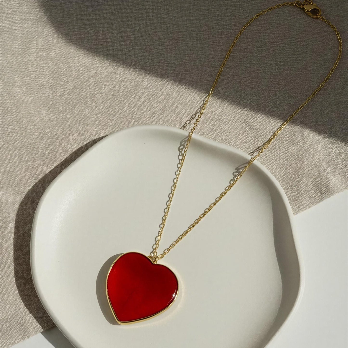 The Rosso Heart Necklace from Chica Chica Jewelry  on a white dish