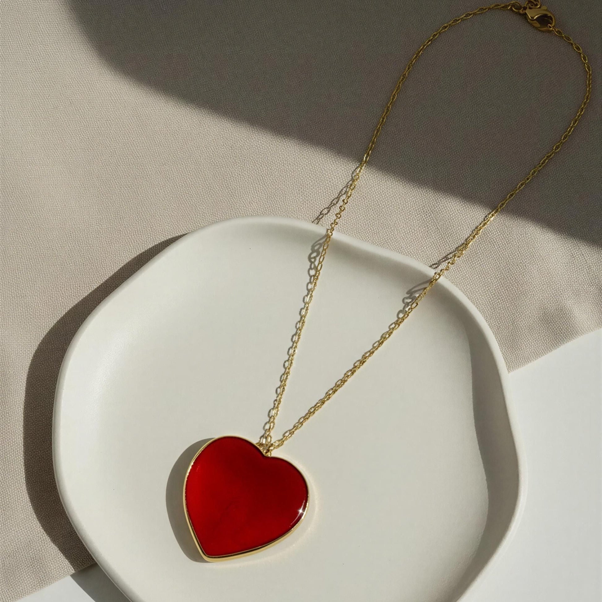 The Rosso Heart Necklace from Chica Chica Jewelry  on a white dish