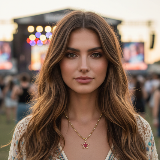 Woman with long brown hair and a star-shaped necklace in a blurred outdoor setting