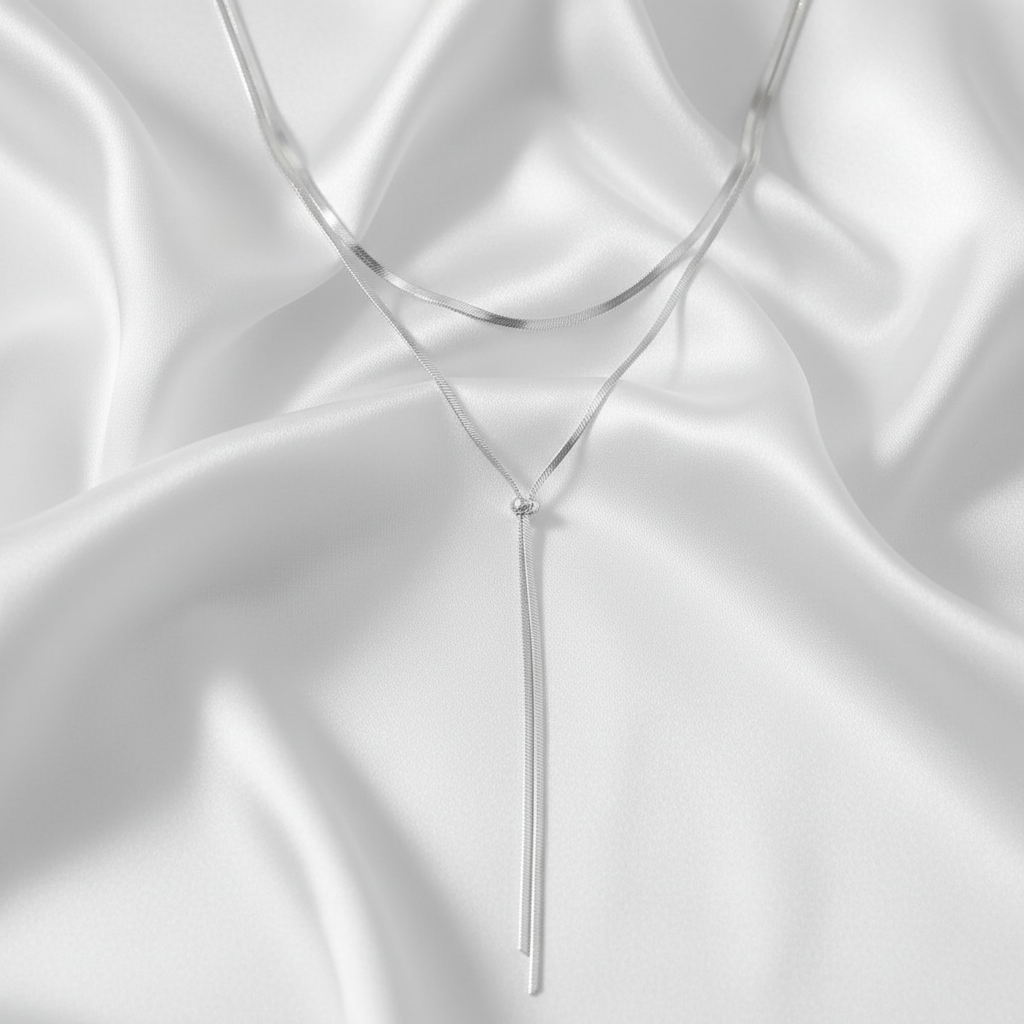 Silver necklace on a white satin background