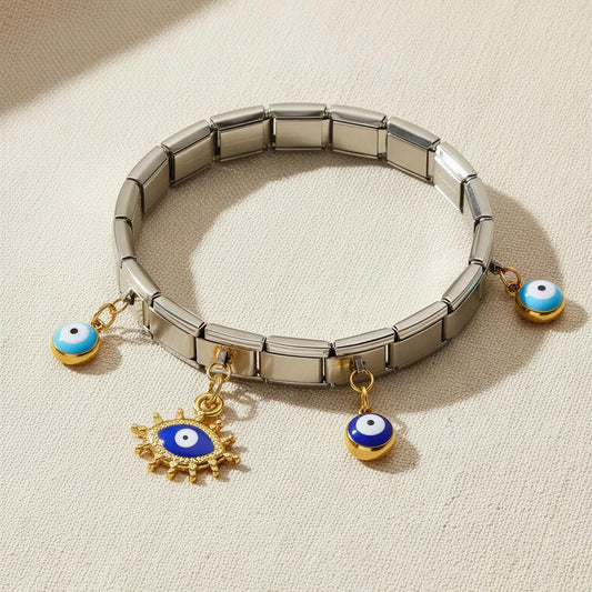 Silver bracelet with evil eye charms on a beige background