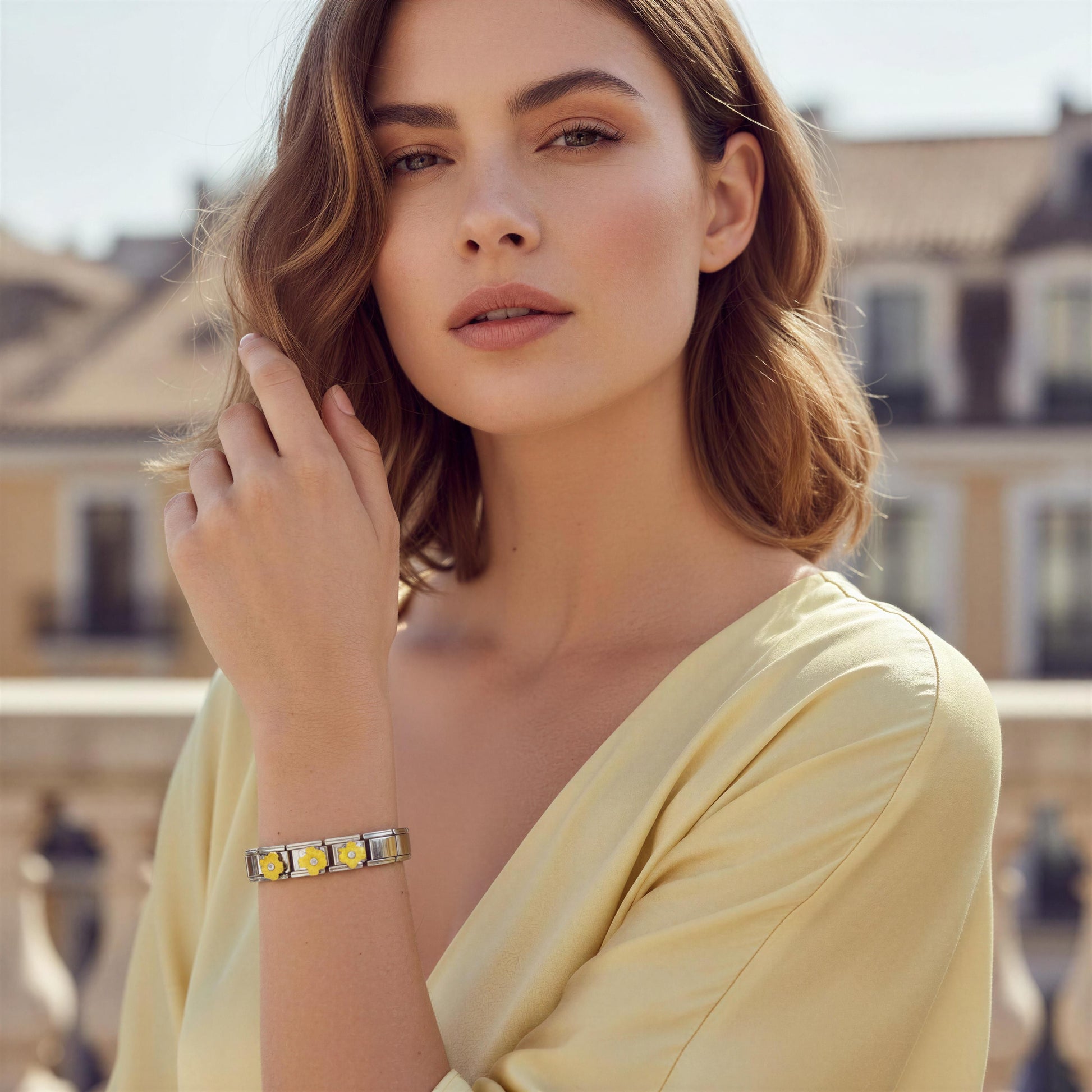 Woman wearing a yellow top and the Sunlit Blossom Bracelet with a blurred background