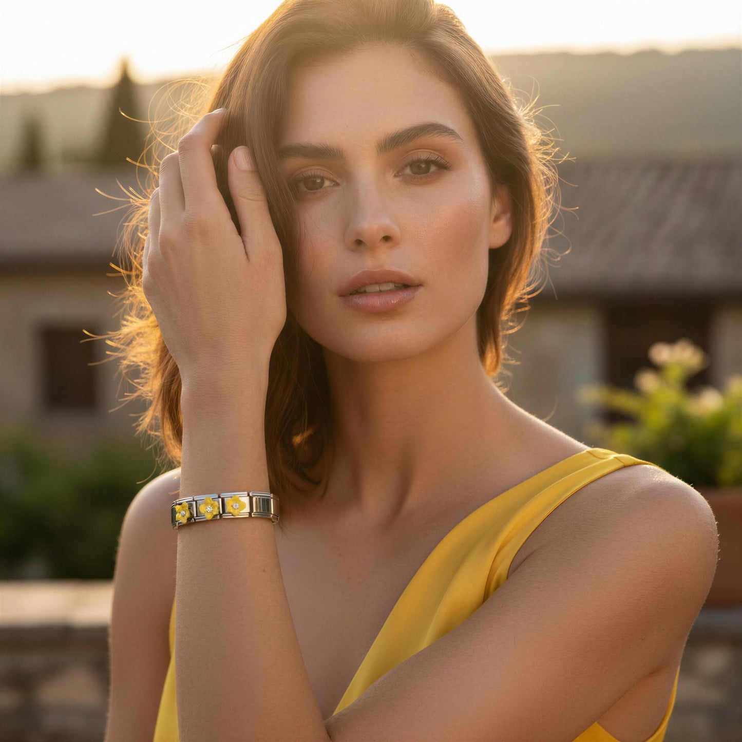 Woman wearing a yellow sleeveless top and the Sunlit Blossom Bracelet with a blurred outdoor background