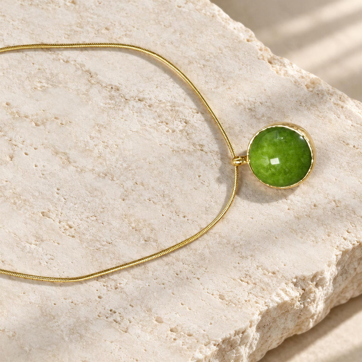 The Verena Necklace from Chica Chica Jewelry against cream color travertine.