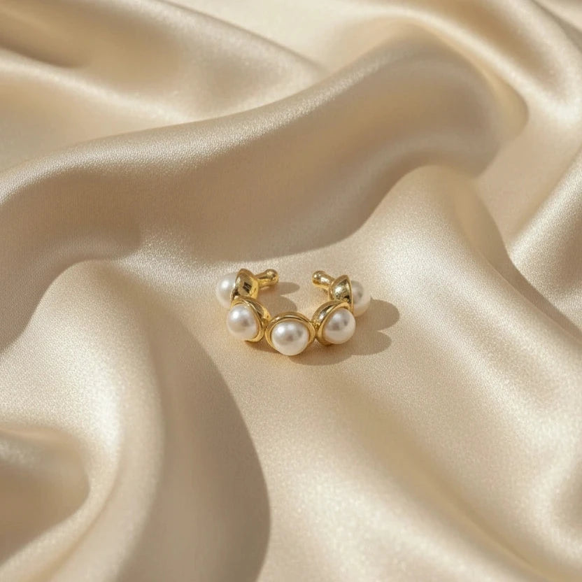 The Celestial Pearl Cuff on beige satin fabric.