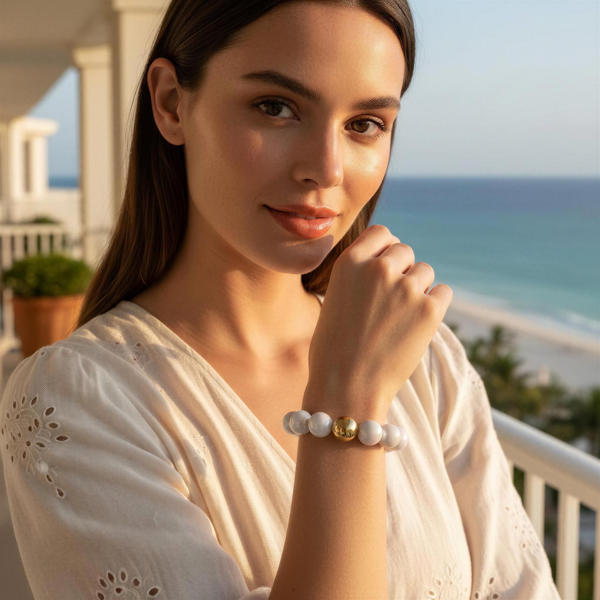 Woman wearing the Coconut Glow Bracelet with a scenic ocean view in the background