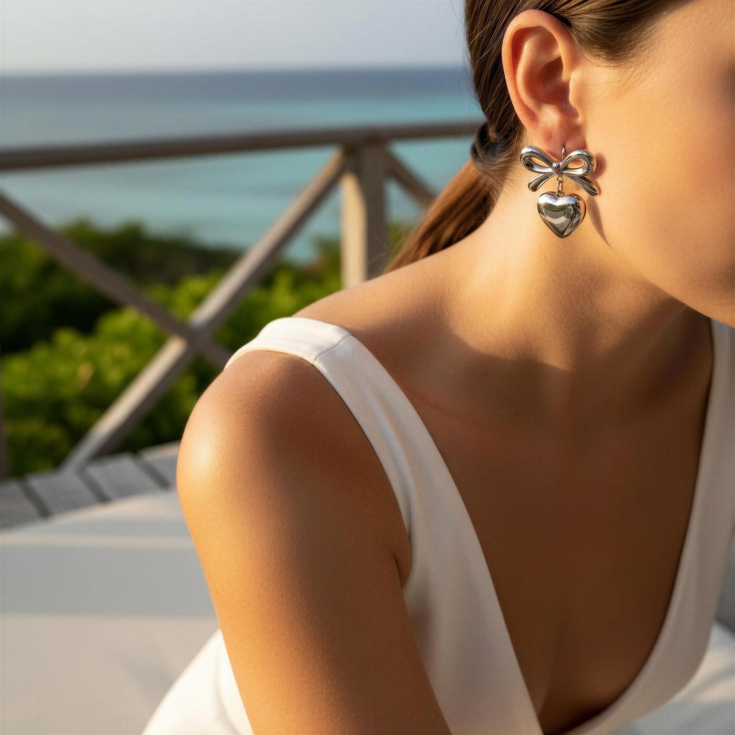 Model wearing the Cupid's Knot Earrings in  Silver on outdoors
