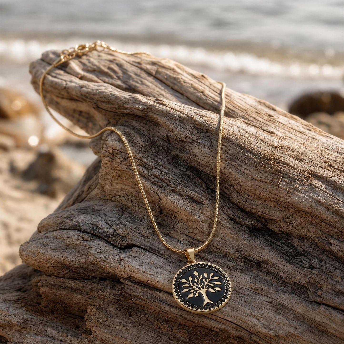 Necklace with a tree pendant on a piece of driftwood by the water