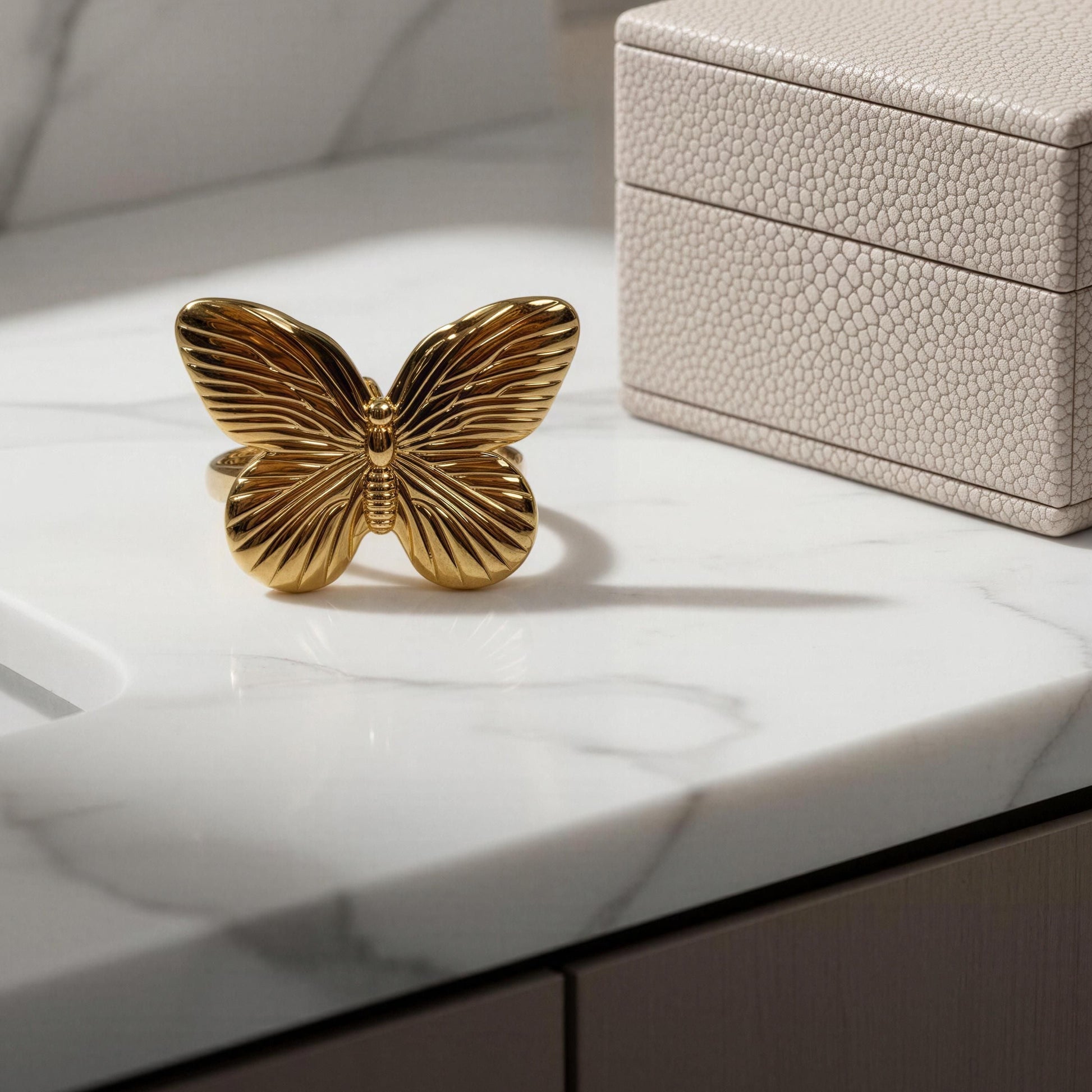 The Forever Flutter Ring - Gold  in a box on a marble countertop.