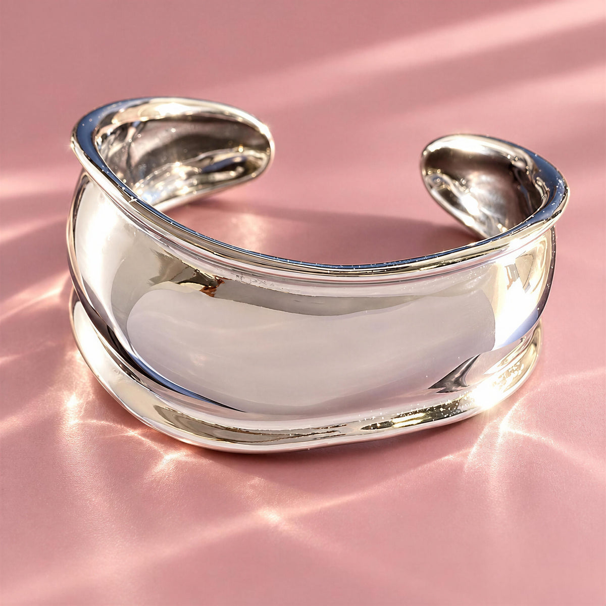 The Forma Cuff Silver from Chica Chica Jewelry against pink fabric.