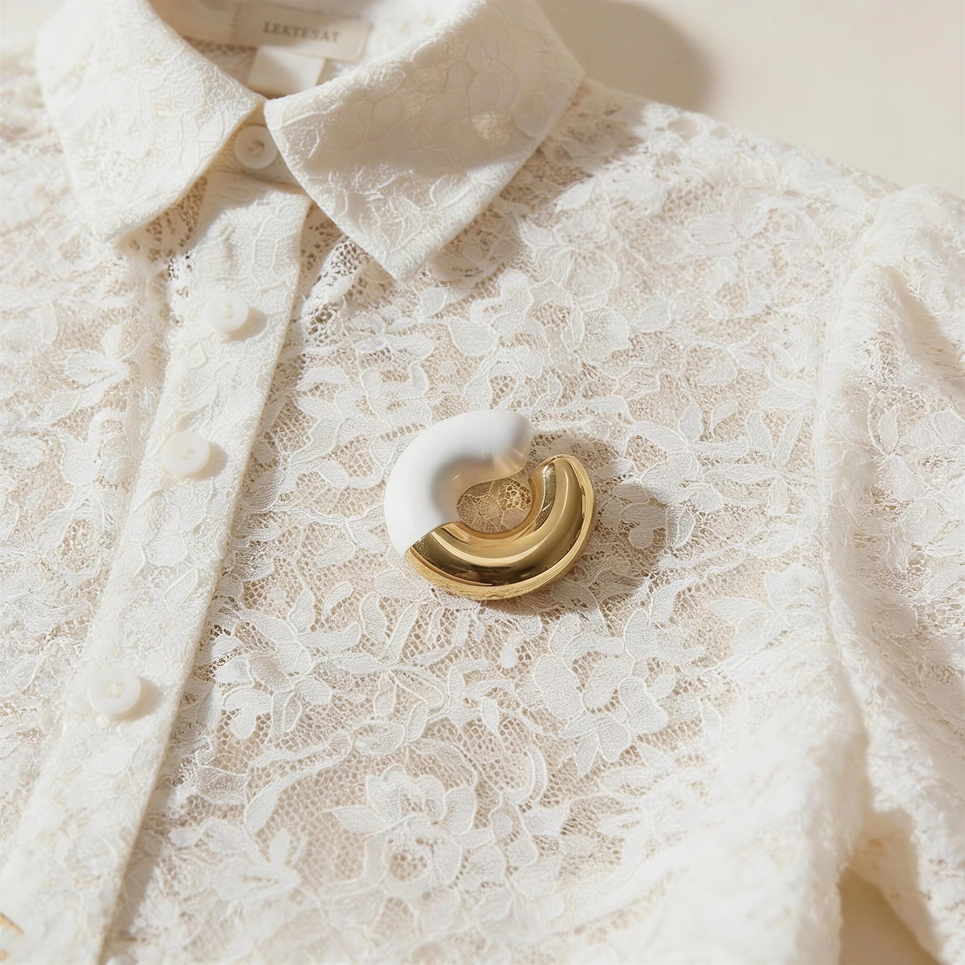 White lace shirt with the Gatsby Arc Ear Cuff  in Milky White on a lace blouse.