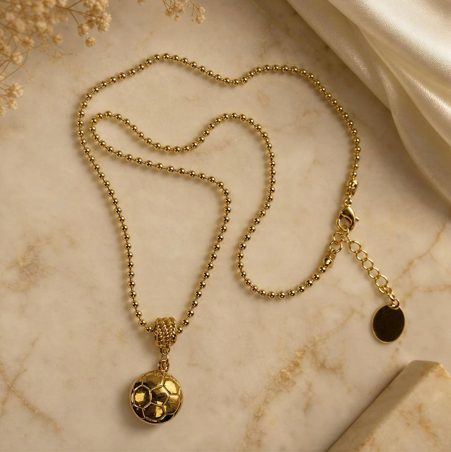 The Gol Dorado Necklace placed against marble surface.