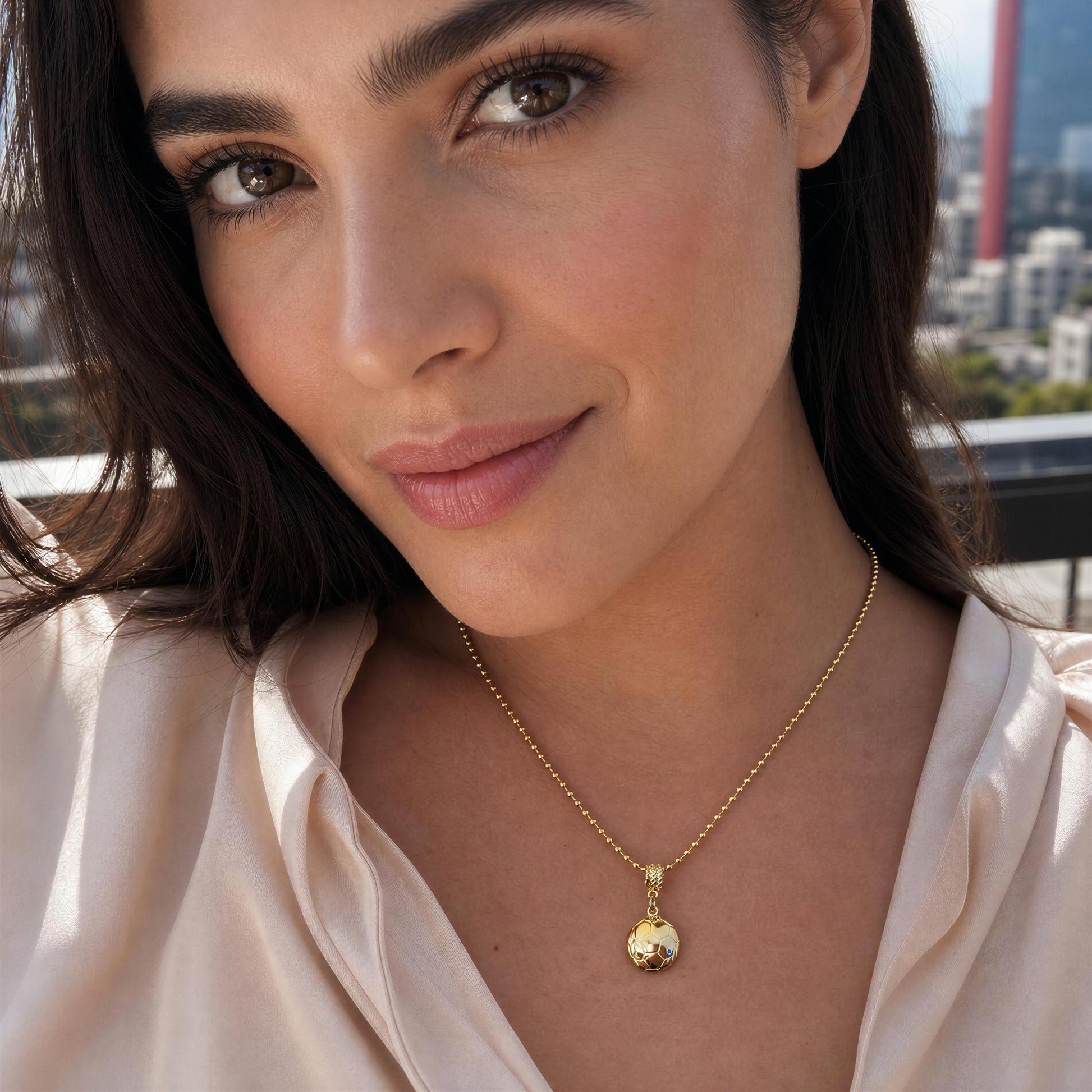 Woman wearing the Gol Dorado Necklace against an urban background