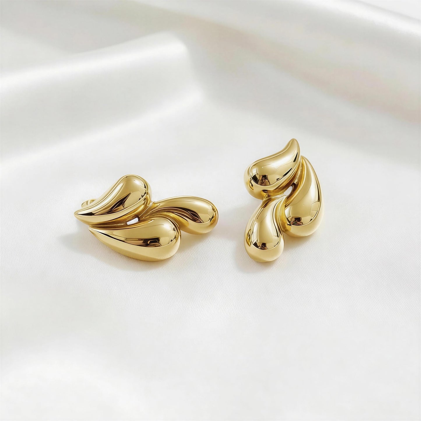 Pair of the  Golden Molten Wave Drops from Chica Chica Jewelry on a white background.
