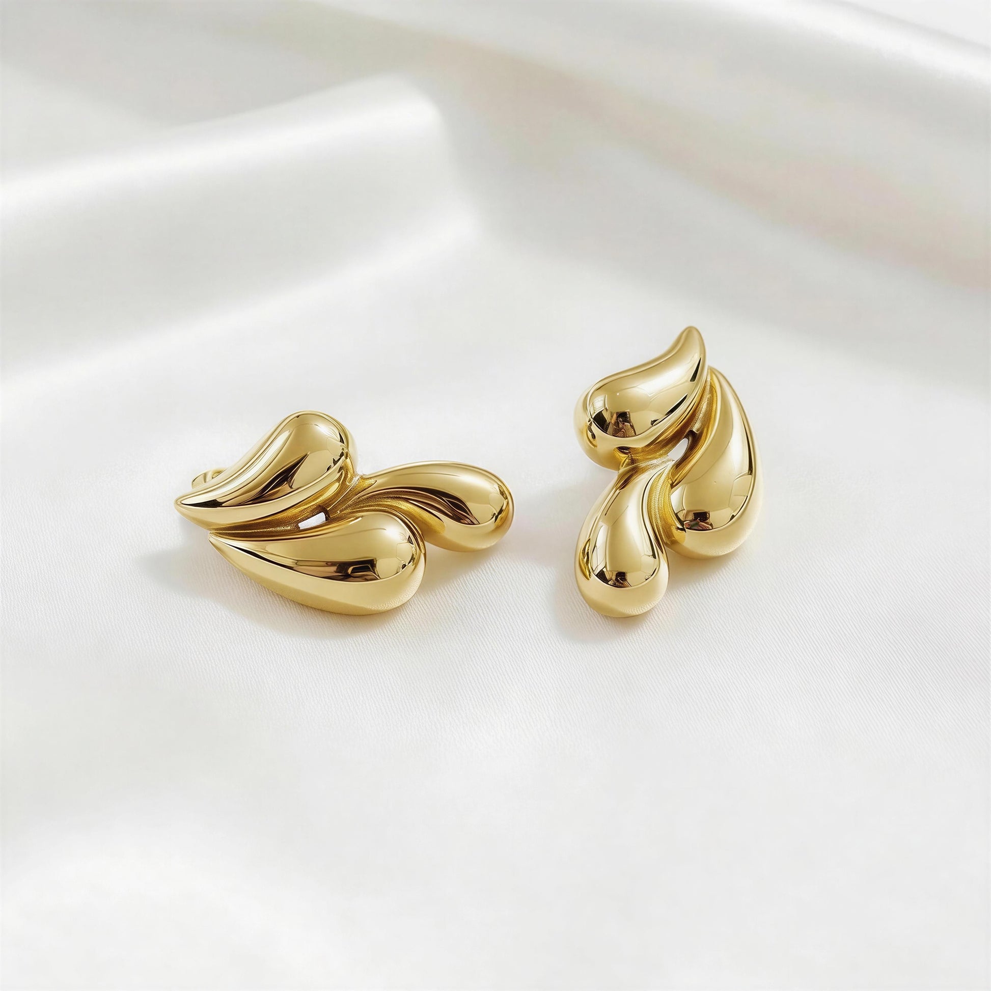 Pair of the  Golden Molten Wave Drops from Chica Chica Jewelry on a white background.