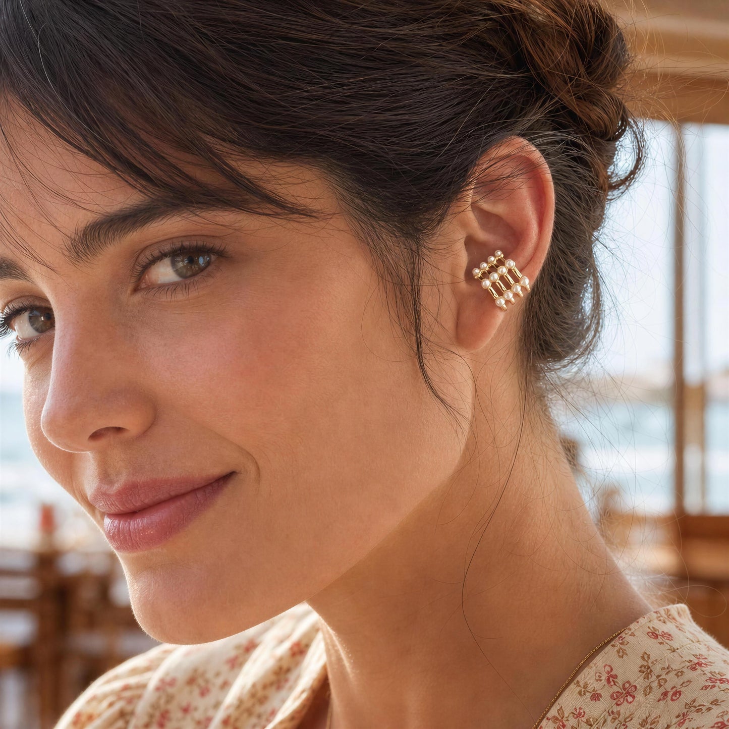 Close-up of a woman wearing the Grid Pearl Ear Cuff with a blurred background.
