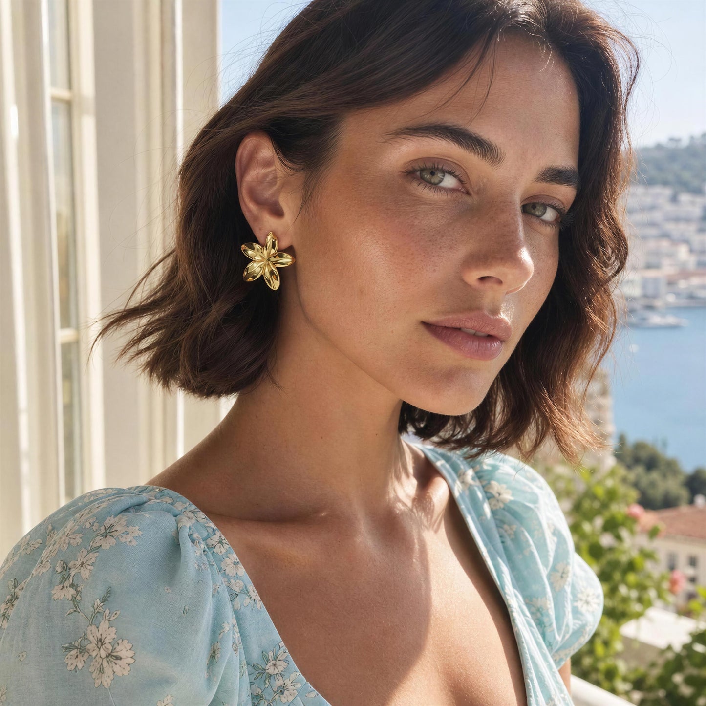 Woman wearing the Luna Bloom Earrings - Gold with a scenic background