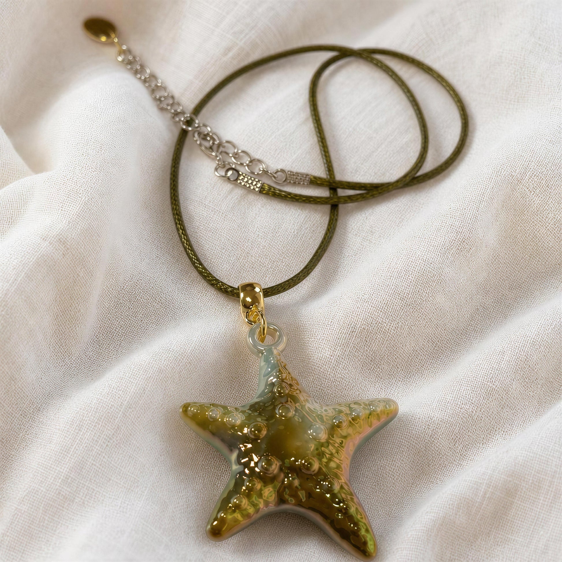 The Nerina Olive Necklace from Chica Chica Jewelry flatlay on linen fabric.
