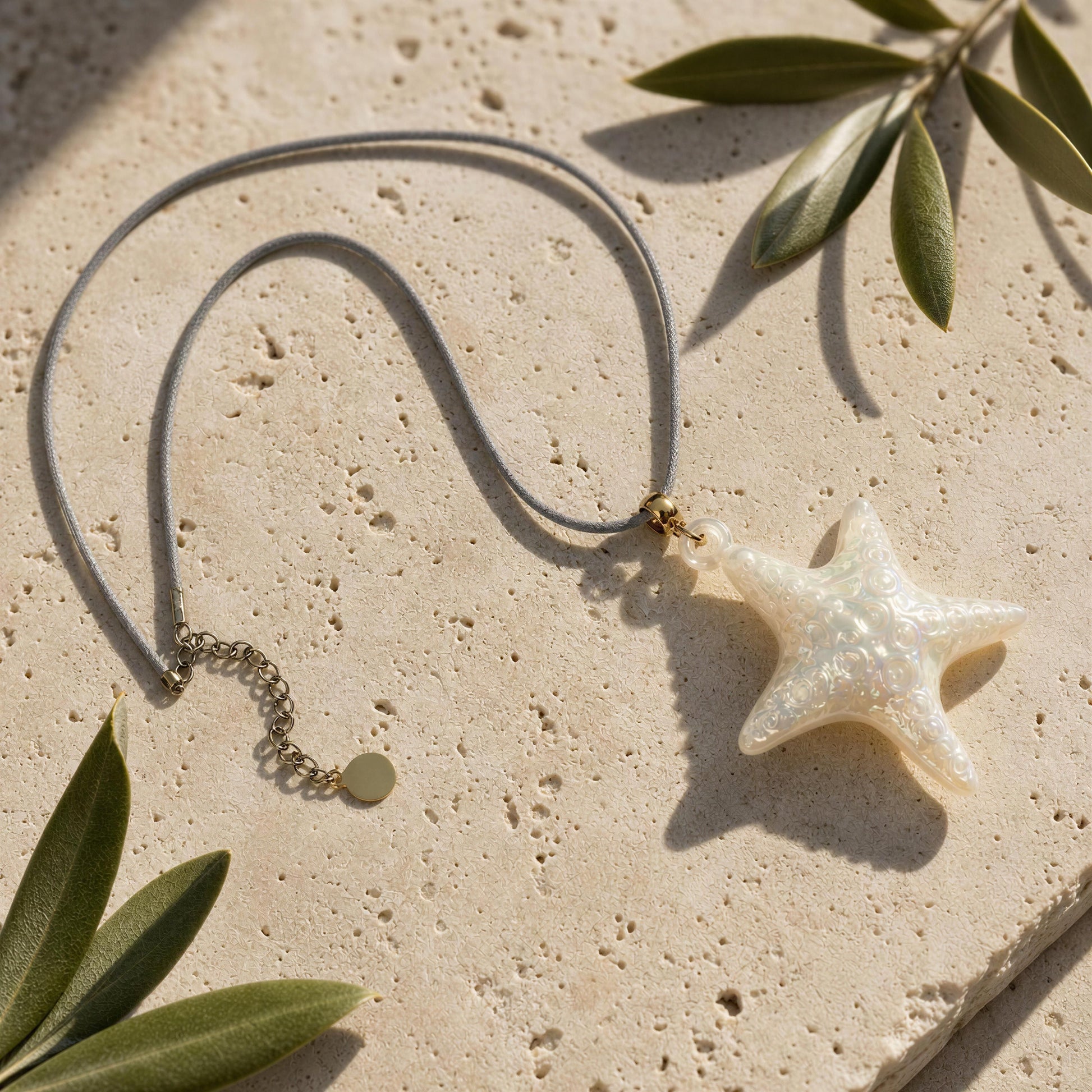 The Nerina Seafoam Starfish Necklace on a travertine background