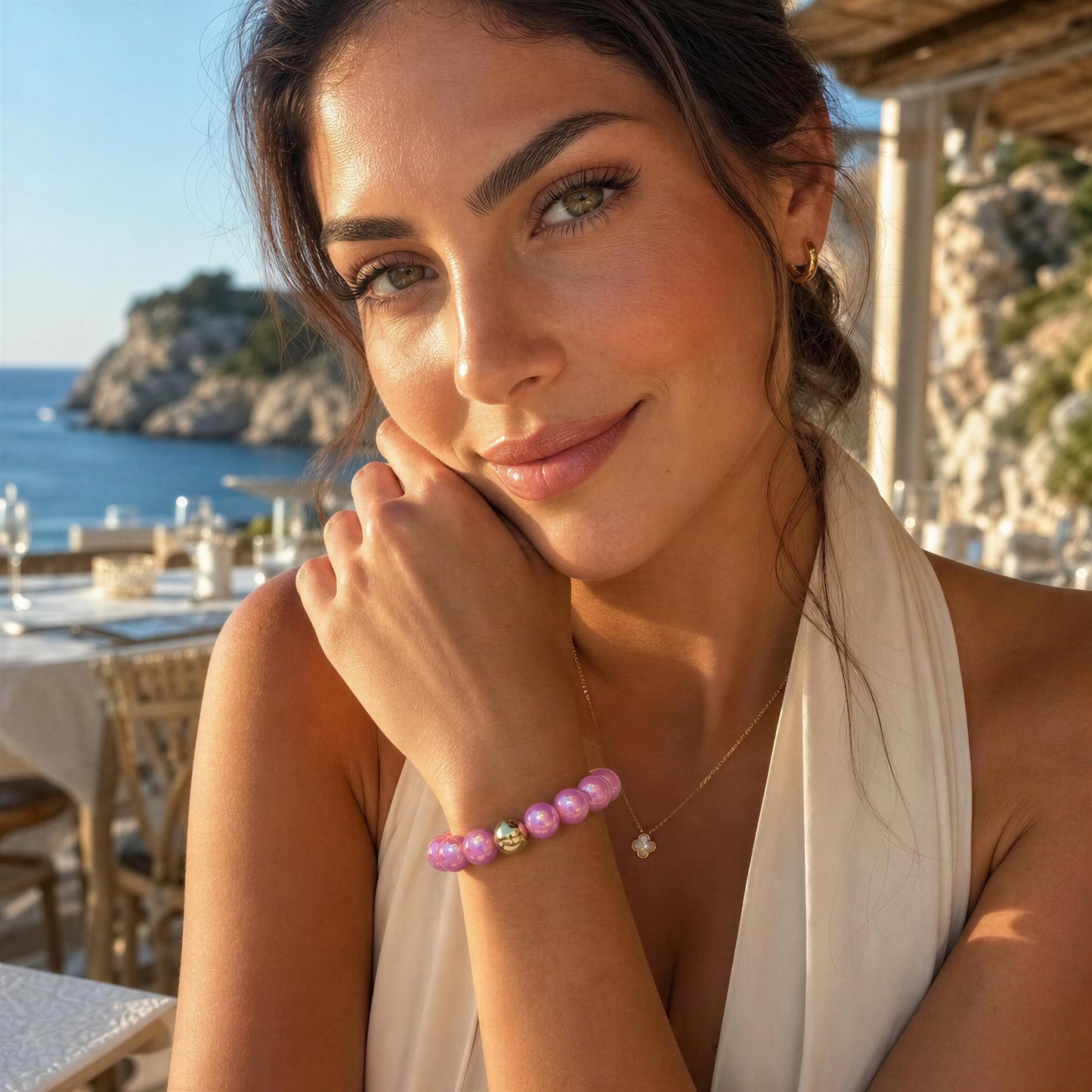 Woman with the Orchid Glow Bracelet sitting by a scenic coastal area