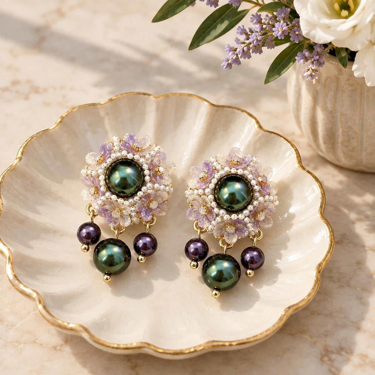 The Paloma Earrings from Chica Chica Jewelry set in a scalloped jewelry dish on marble table.