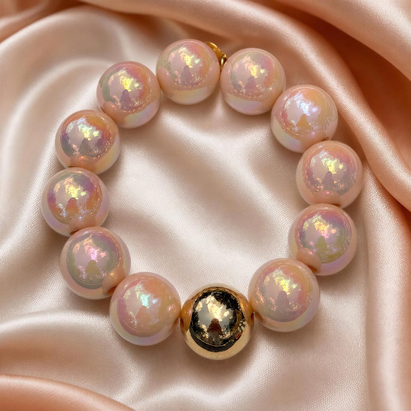 The Peach Glow Bracelet on a pink satin background