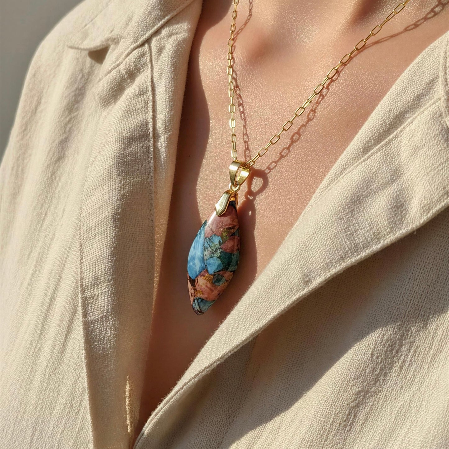 The Pietra Alba Natural Stone Necklace from Chica Chica Jewelry, worn by a person in a beige linen shirt.
