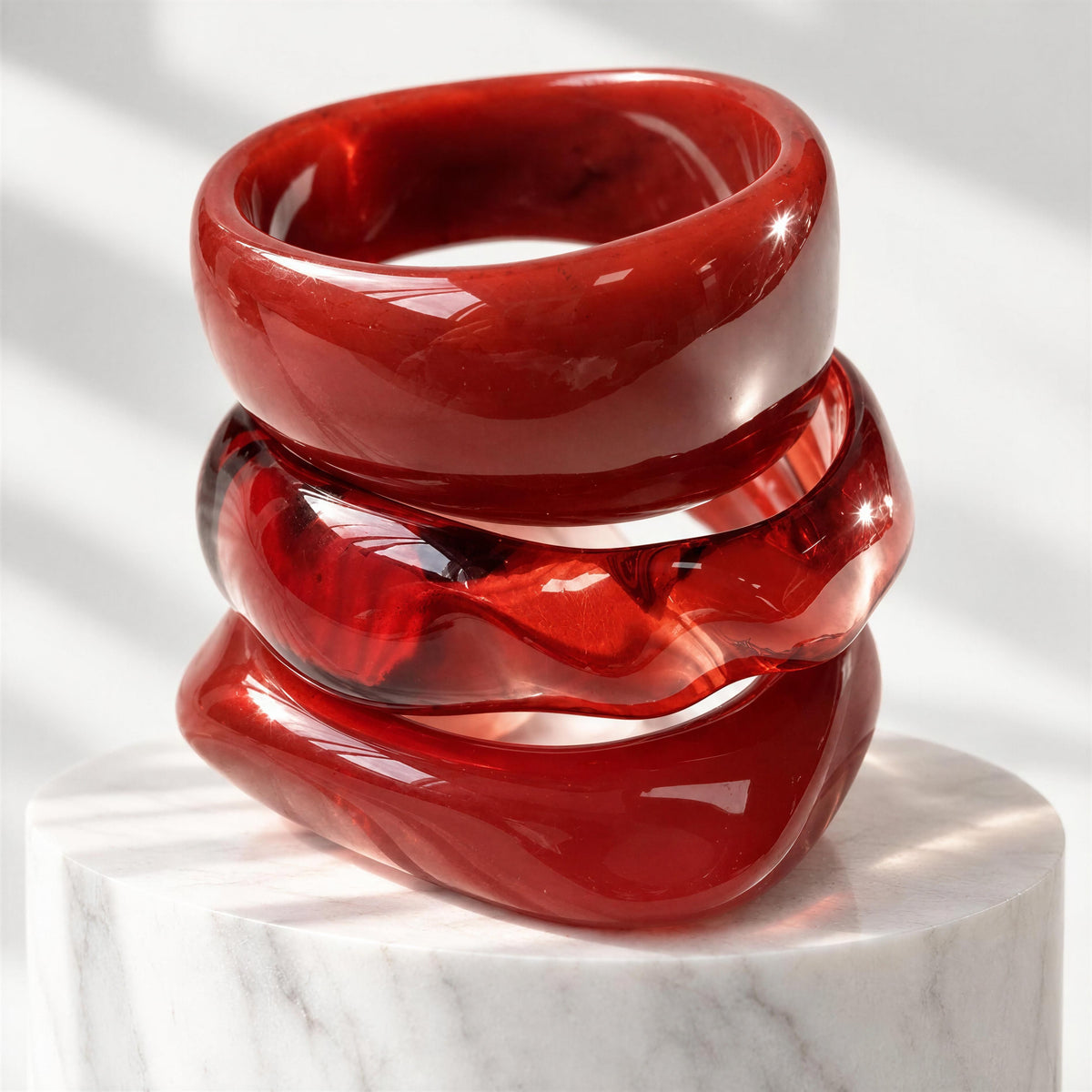 The Radicchio Bangle Set from Chica Chica Jewelry set on a tall marble pedestal. 