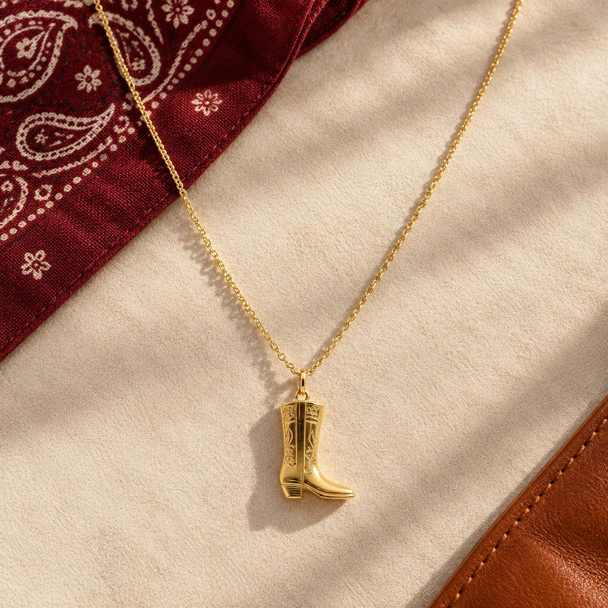 The Rodeo Necklace fromChica Chica Jewelry against ivory fabric, red bandanna and leather piece.