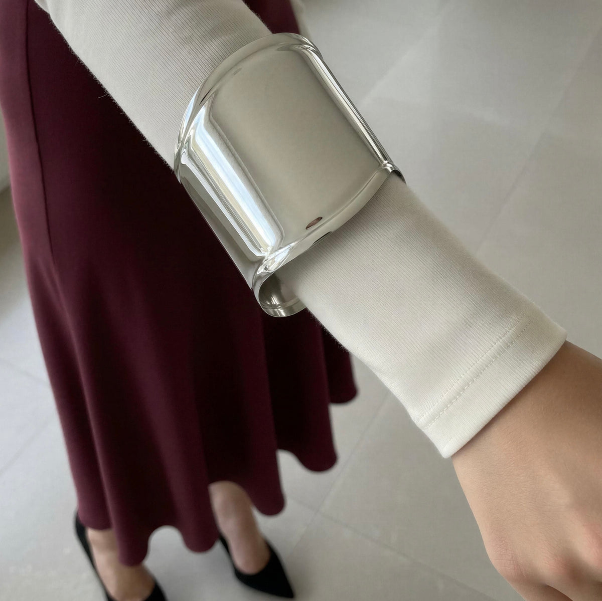 Model wearing the Roma Cuff from Chica Chica Jewelry and a burgundy skirt and a white crisp shirt.