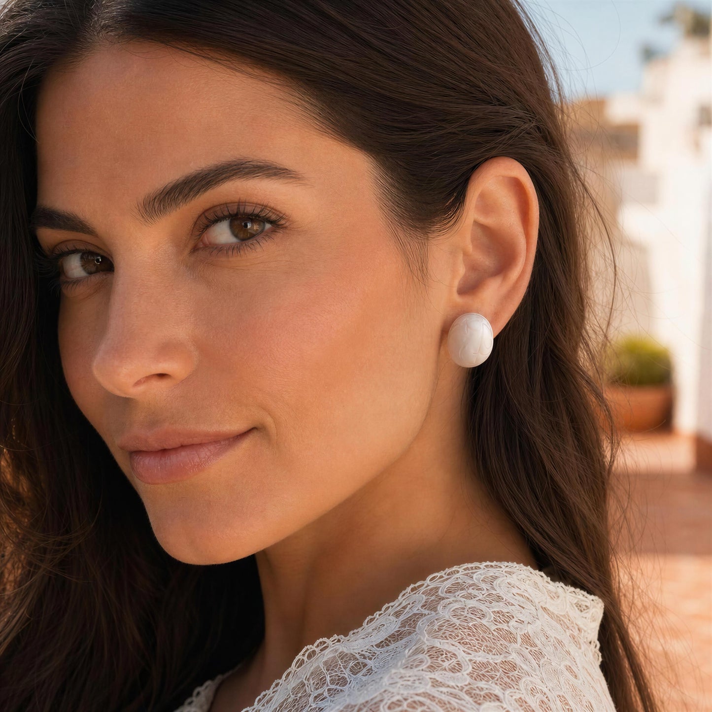 Close-up of a woman wearing the Rosina Studs - Ivory Mist with a blurred outdoor background