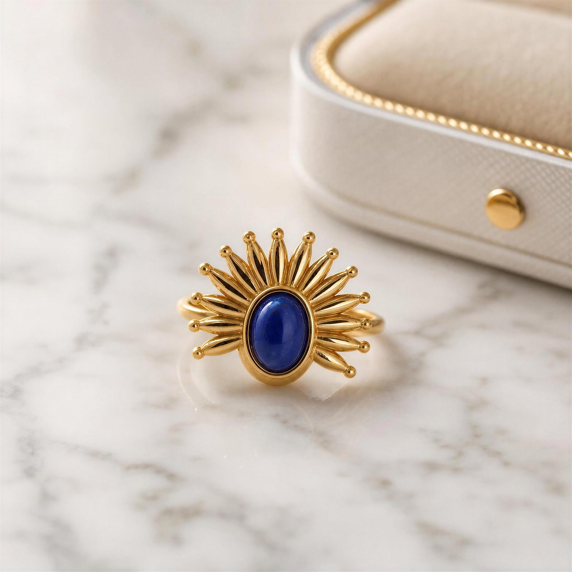The Solara Ring on a marble surface with a jewelry box in the background
