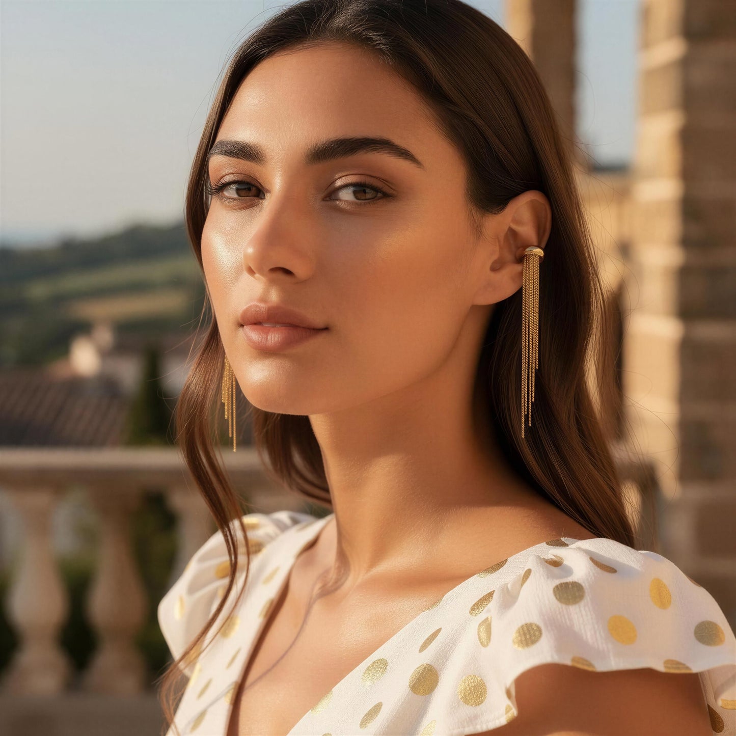 Woman wearing the Vela Gold Ear Cuff with a scenic background