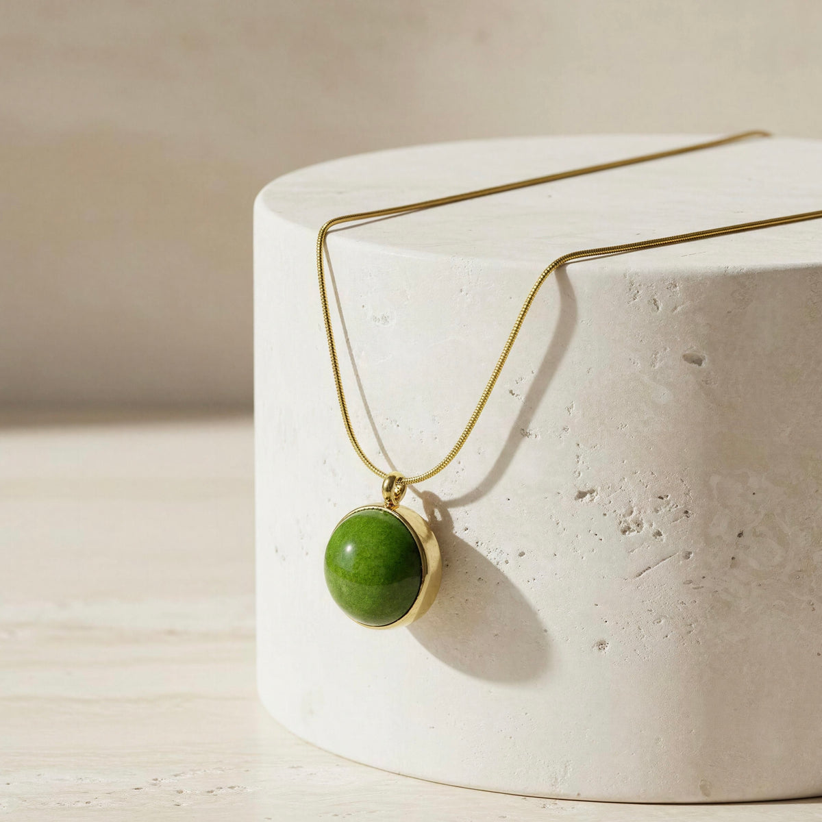 The Verena Necklace, Chica Chica Jewelry draped on a white marble cylinder.