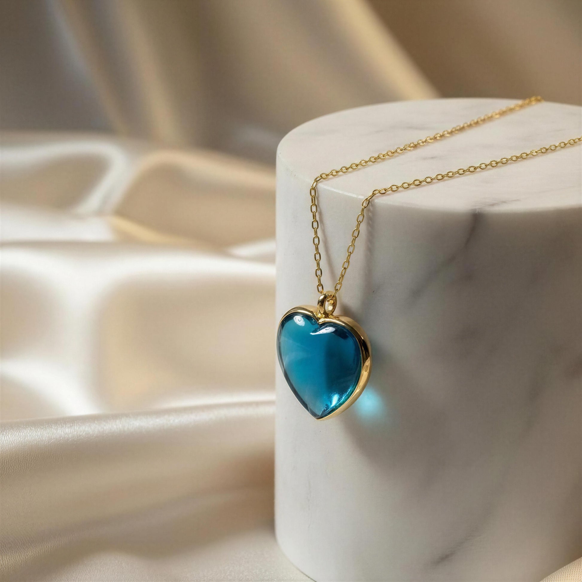 The Turquoise Murano Heart Necklace on a white cushion