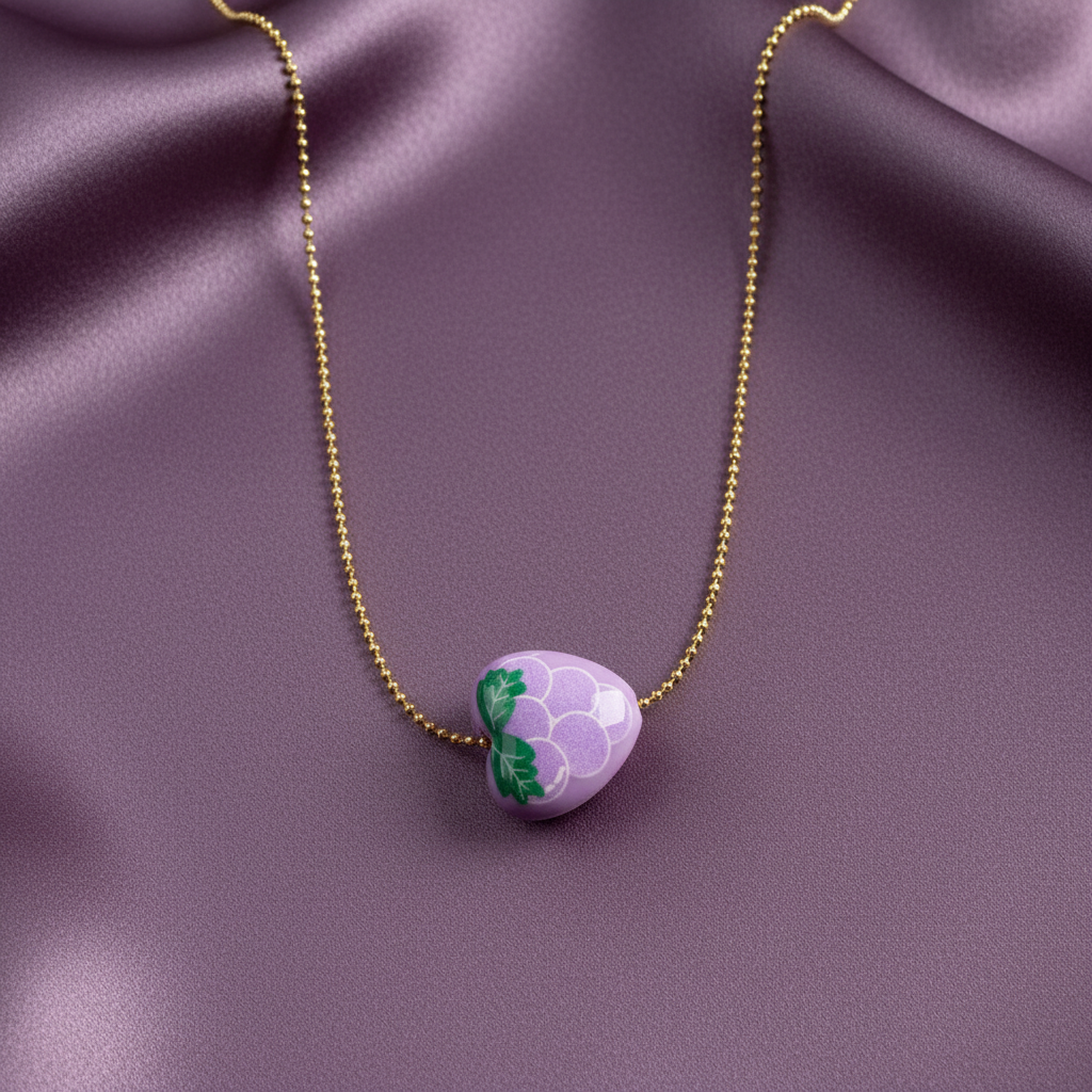 Close-up of lavender grape charm on an adjustable 18K gold-plated ball chain