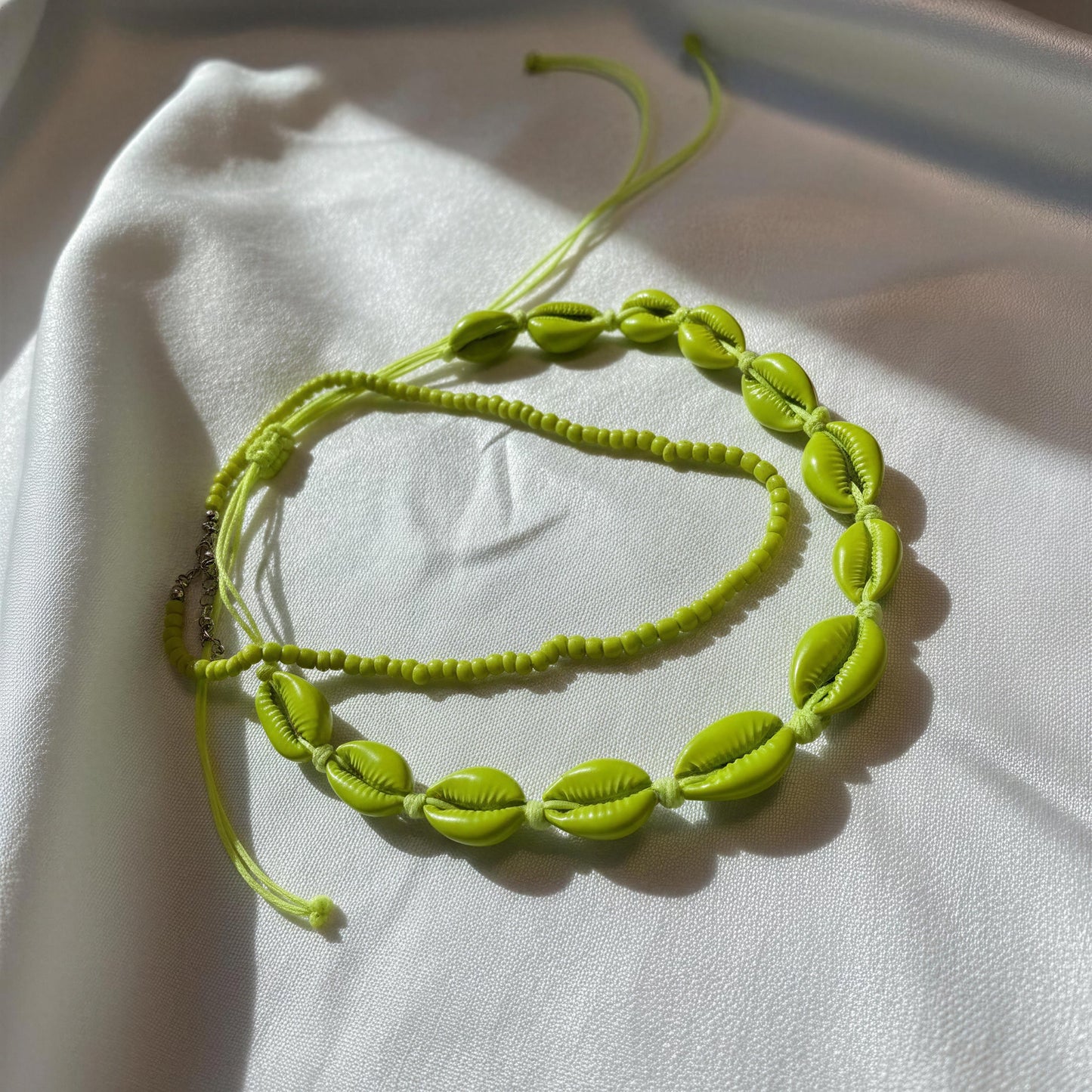 Verde Mare Necklace on a white fabric background