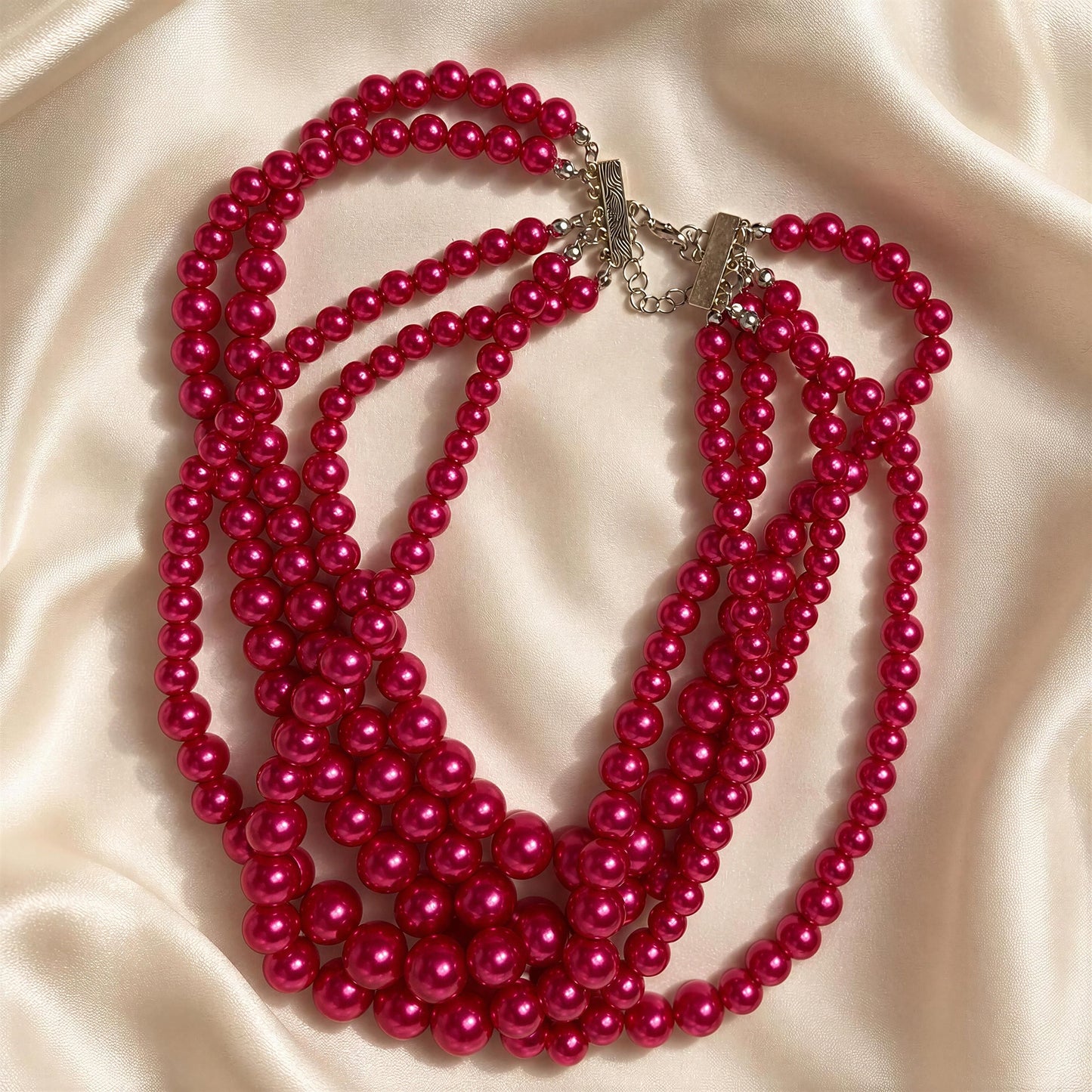 The Vienna Rose Pearl Cascade Necklace on a beige fabric background