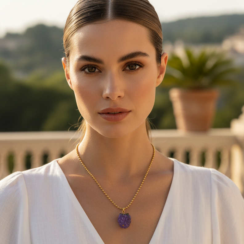 Woman wearing a gold necklace with a purple pendant outdoors