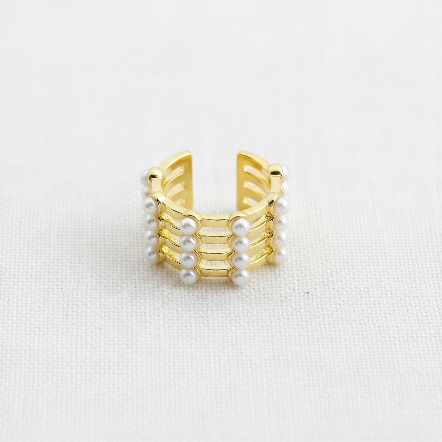 The Grid Pearl Ear Cuff featuring pearl accents and 18K gold-plated architectural detailing on a light gray background.