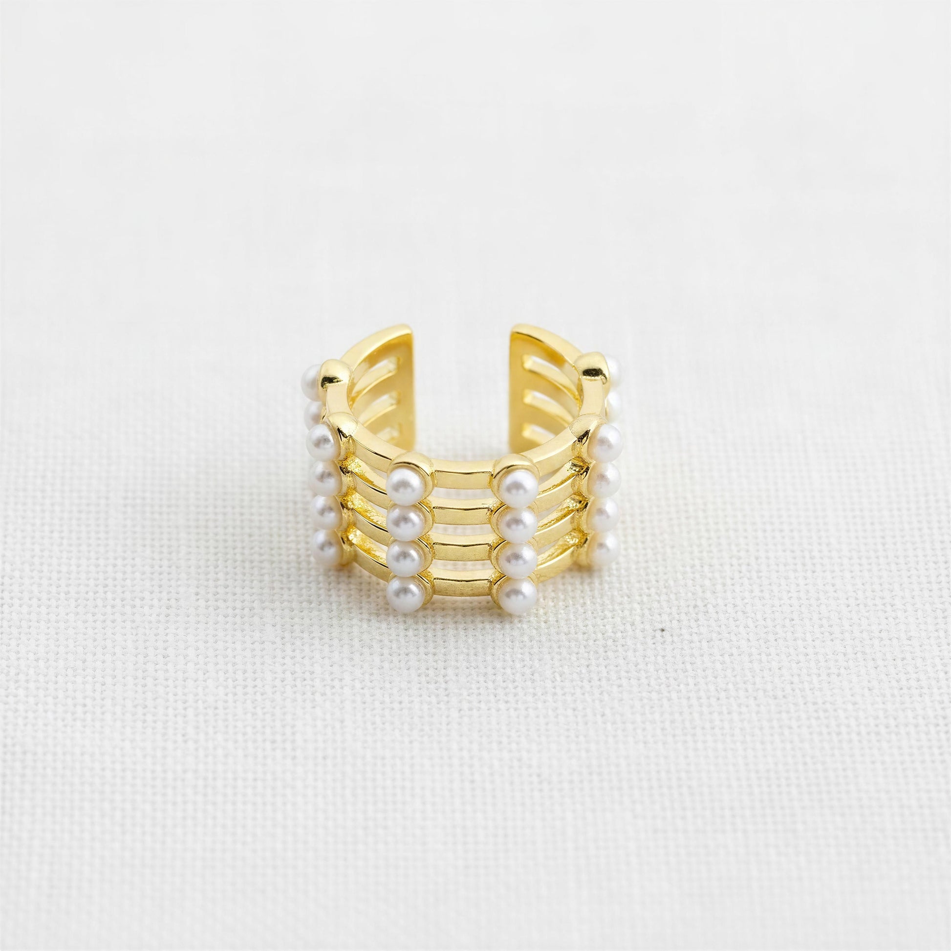 The Grid Pearl Ear Cuff featuring pearl accents and 18K gold-plated architectural detailing on a light gray background.